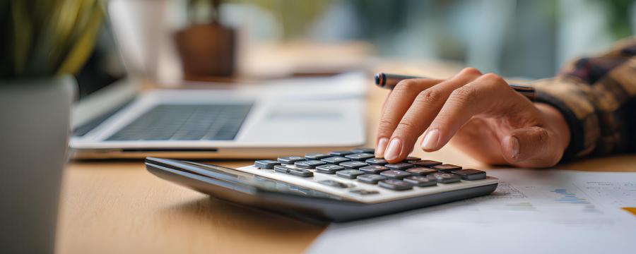 Lohnkosten Sujetbil Hand mit Computer und Taschenrechner