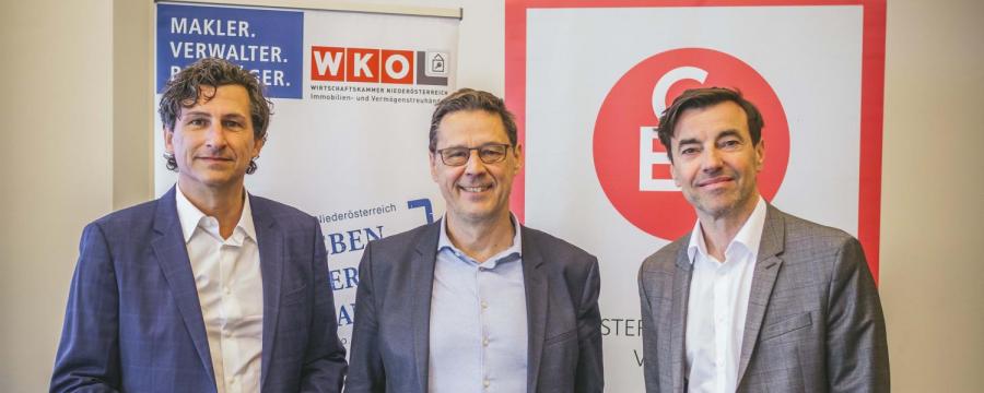 3 Männer vor Plakaten