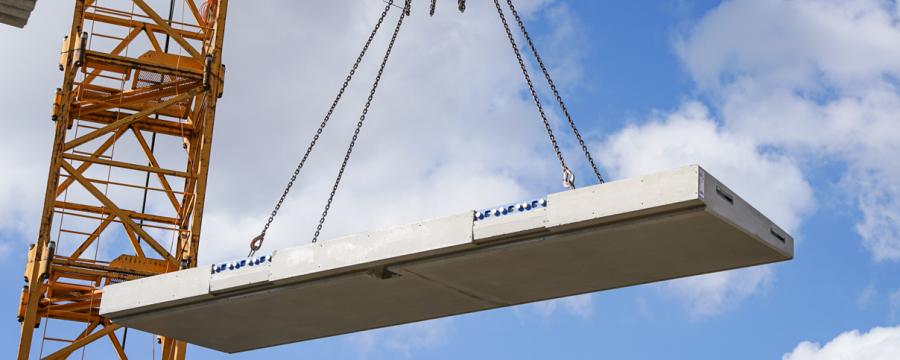 Just-in-time auf der Baustelle: Die Balkonplatte wird als Fertigteil an die Baustelle geliefert und mittels eines Krans zur jeweiligen Anschlussstelle des Gebäudes gehoben. Der deckenseitige Part von Schöck Isokorb IQ K wurde vorab im Gebäude verbaut. Im Bild: Projekt Seidengasse 32 im 7. Wiener Gemeindebezirk der OBENAUF Immobilienentwicklung GmbH.