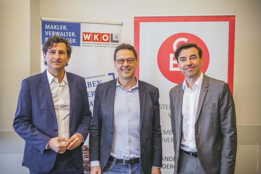 3 Männer vor Plakaten