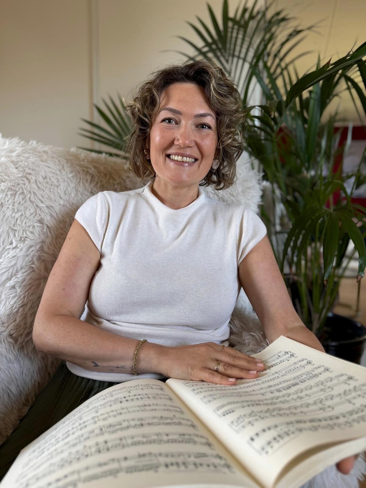 Julia Zubar met een partituur in haar pianopraktijk in Groningen