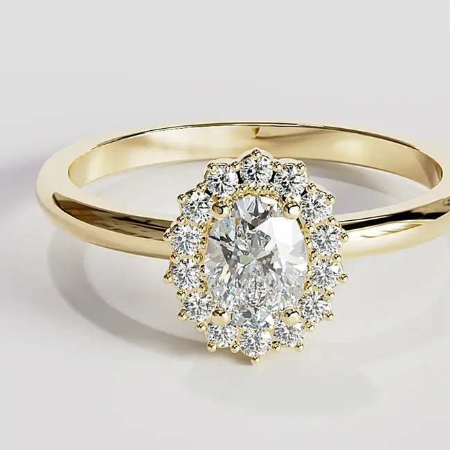 Nahaufnahme eines ovalen Rings aus Gelbgold mit Diamant-Halo