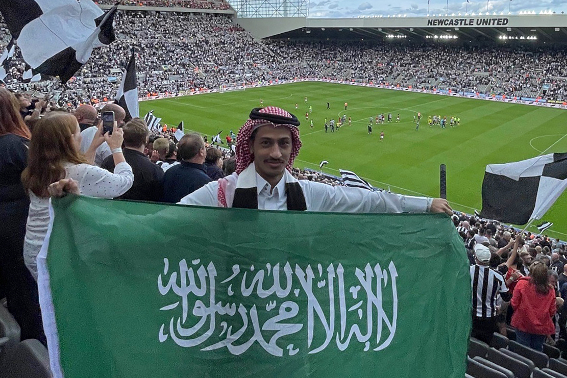 Saudi Abdul Rahman al-Qahtani carries the Saudi national flag during the English Premier League football match between Newcastle United and Nottingham Forest (©AFP)