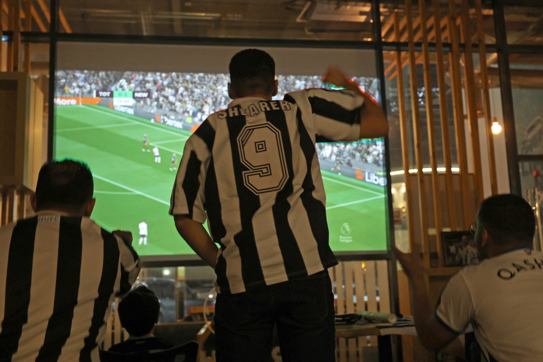 Saudi fans of English football club Newcastle United celebrate a goal scored against Tottenham during as they watch the match at a cafe, in Riyadh on October 23 (©AFP)