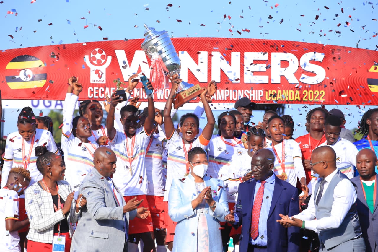 Hasifa Nassuna hoisting the 2022 CECAFA Senior Women's Championship trophy as Uganda celebrate