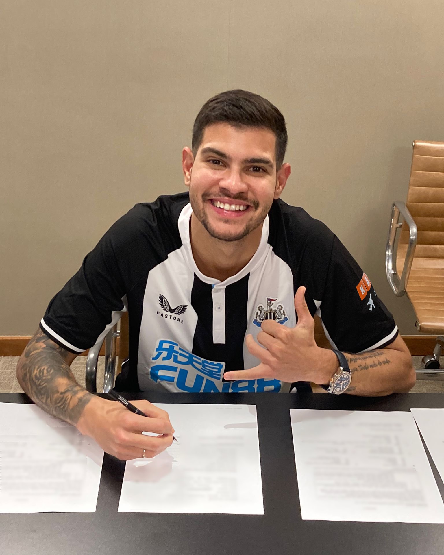Guimaraes signs the contract with Newcastle (©TW/NUFC)