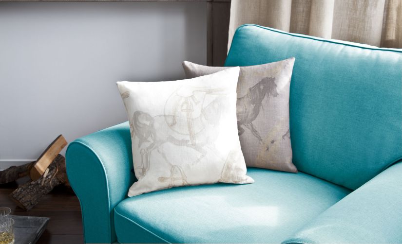 Fauteuil bleu pétrole avec coussins blancs