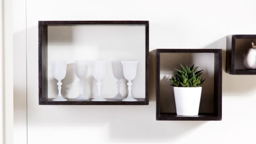 Verres blancs sur une étagère de bois noir