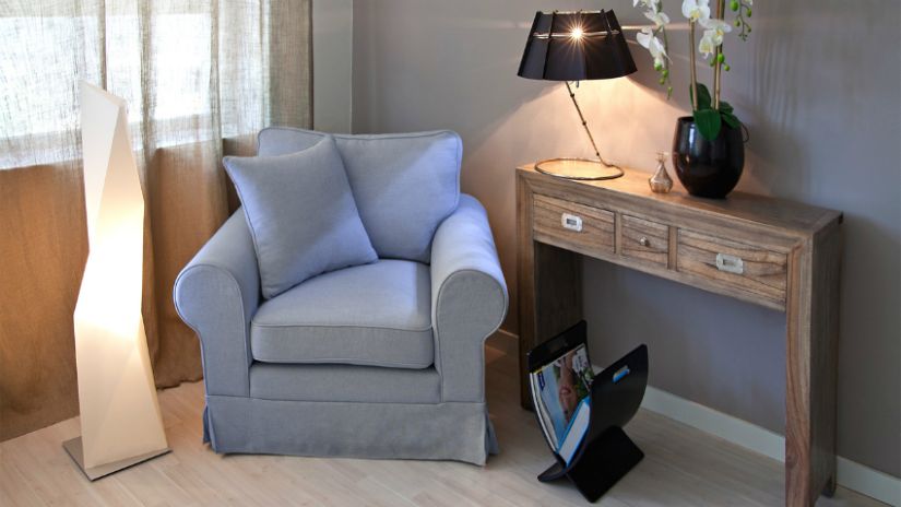 Fauteuil gris et console dans un salon