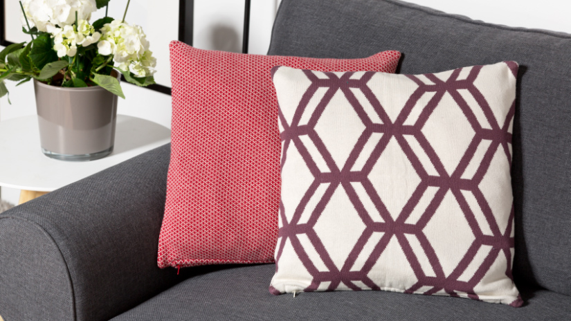 Coussin carré bordeaux sur un canapé
