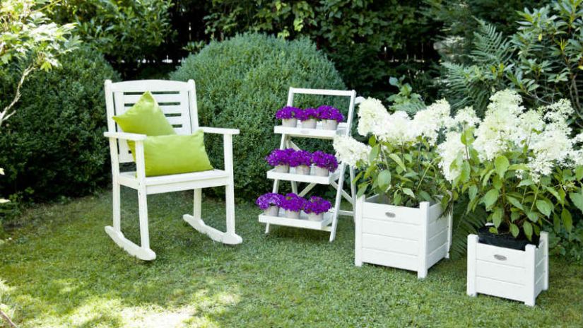 Jardinière en bois avec fleurs blanches et violettes