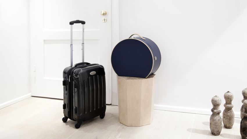 Valise rigide noire dans un hall d'entrée