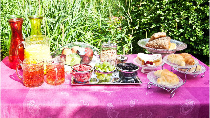 donkerroze plastic tafelkleed op tuintafel