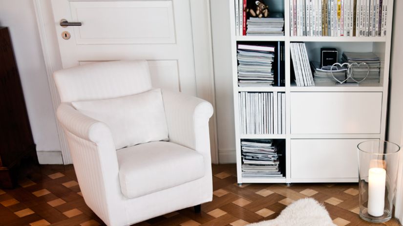 kurkvloer witte fauteuil en witte boekenkast