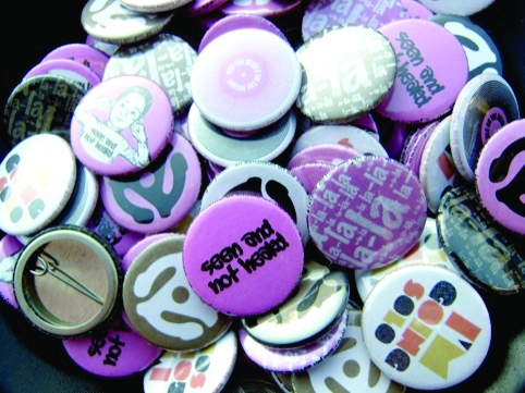 Pin badges promoting the event Seen and Not Heard