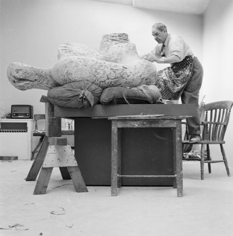 Henry Moore in his studio working on a plaster sculpture, 1960