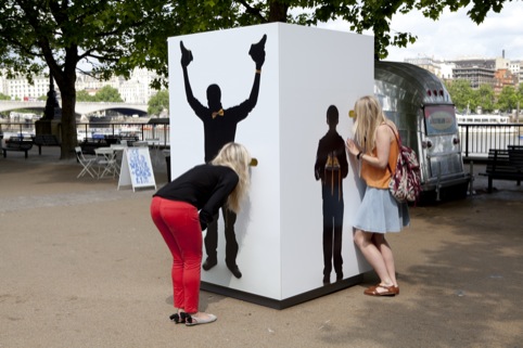 A lady in red peers through the peephole
