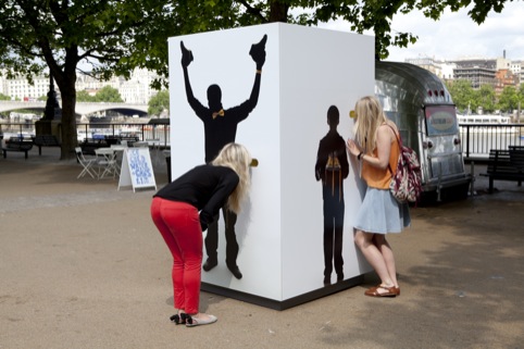 A lady in red peers through the peephole