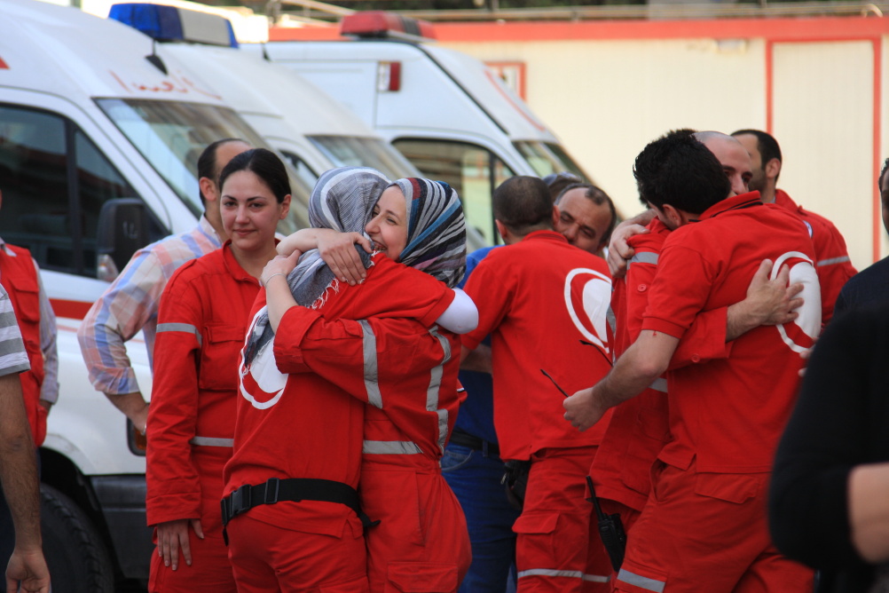 Syria: Humanity in Conflict at IWM North. SARC volunteers returning from a dangerous mission greet their friends outside the SARC centre in Zahira, Damascus, 25 April 2012. The group was trapped in Douma in rural Damascus for 12 hours due to violent clash