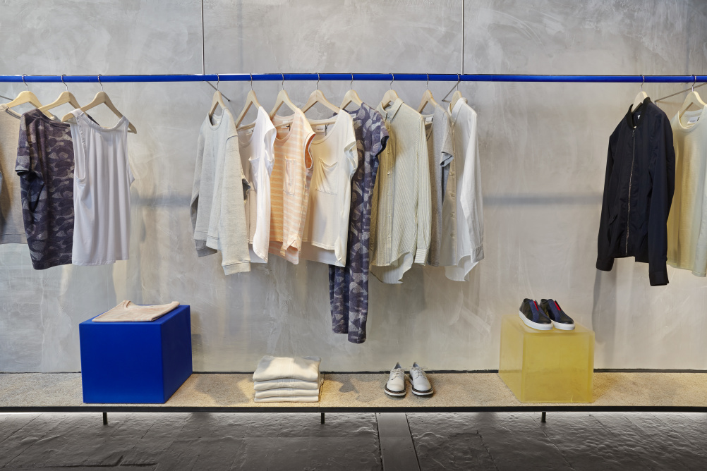 A blue clothing rail and raw concrete wall