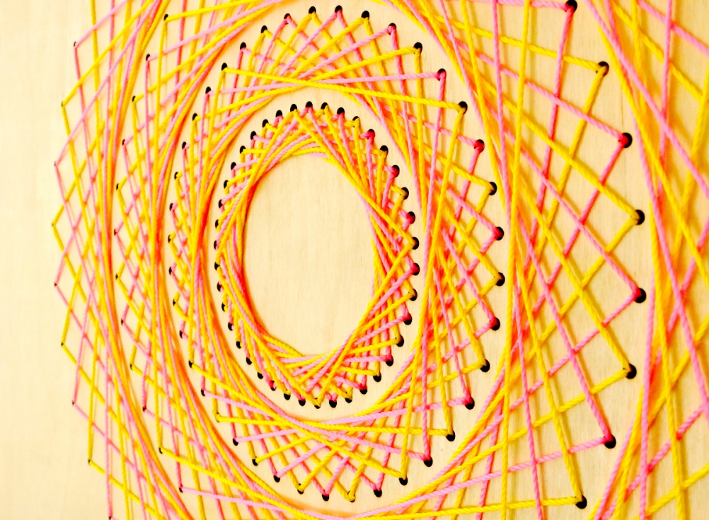 By Mr Gresty. Laser cut ply wood with yellow and pink string 