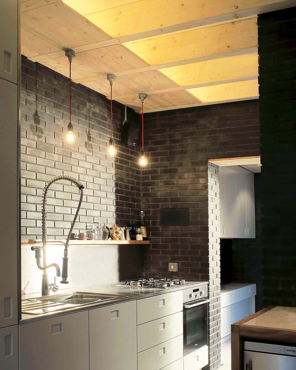 loft style kitchen with untreated wood, exposed brick and simple bulb lights