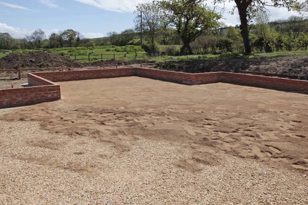 Coarse sand is added over the compacted stone