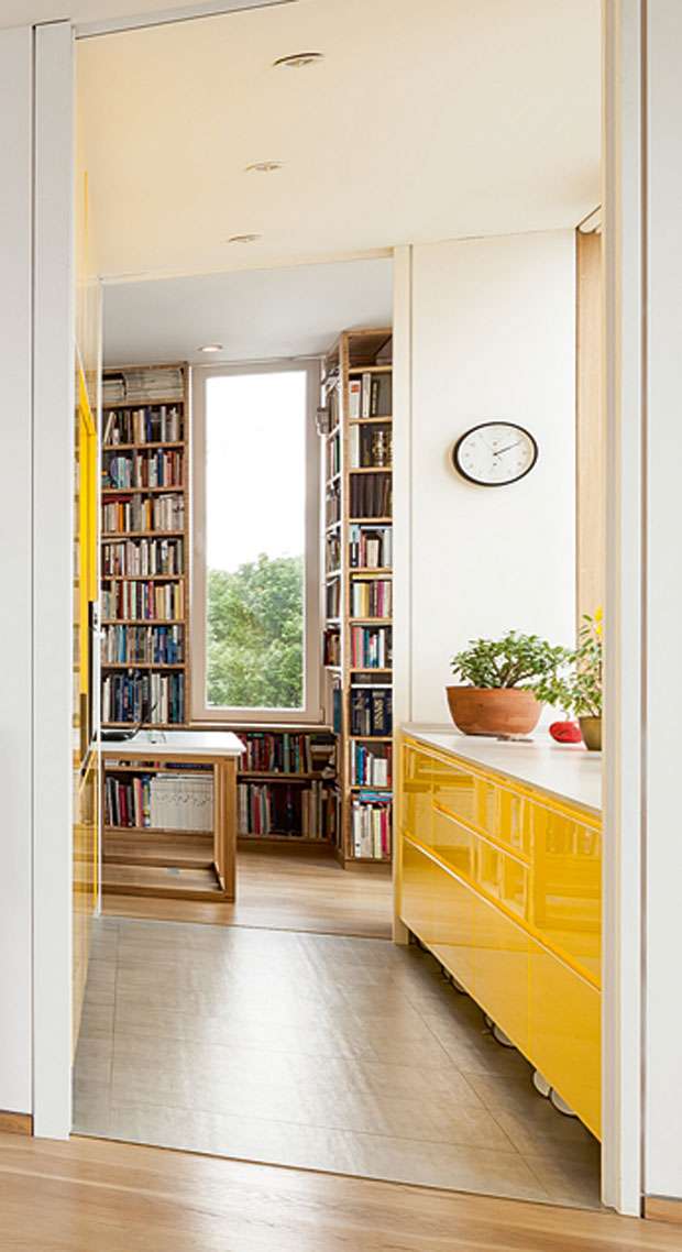tall picture window surround by books and a reading nook