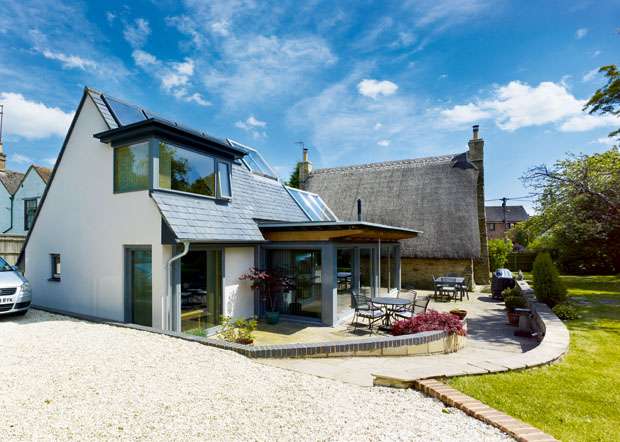Thatched-with-glazed_side-of-modern-building-and-thatched-house