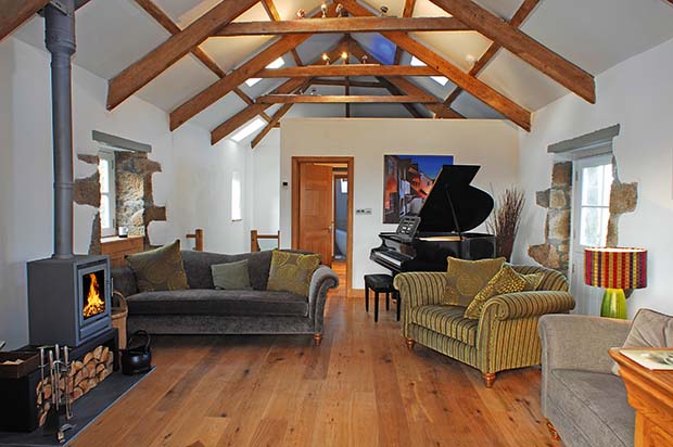 Grand piano and woodburning stove in a holiday barn in Padstow Cornwall