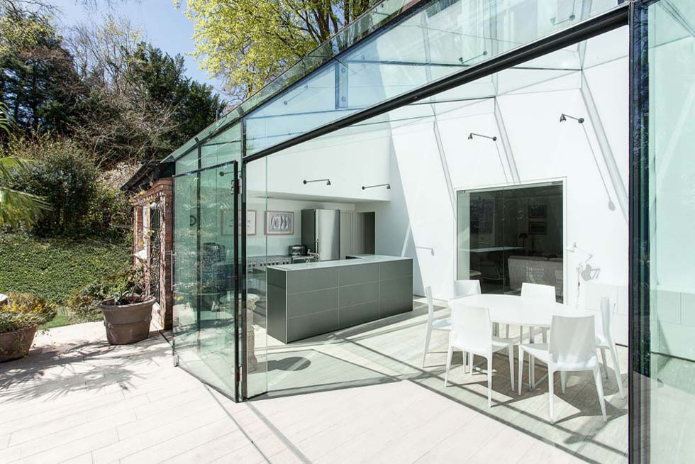 This frameless glass extension, by AR Design Studio, has created a modern kitchen-diner for seamless entertaining between the inside and outside spaces. View Project →