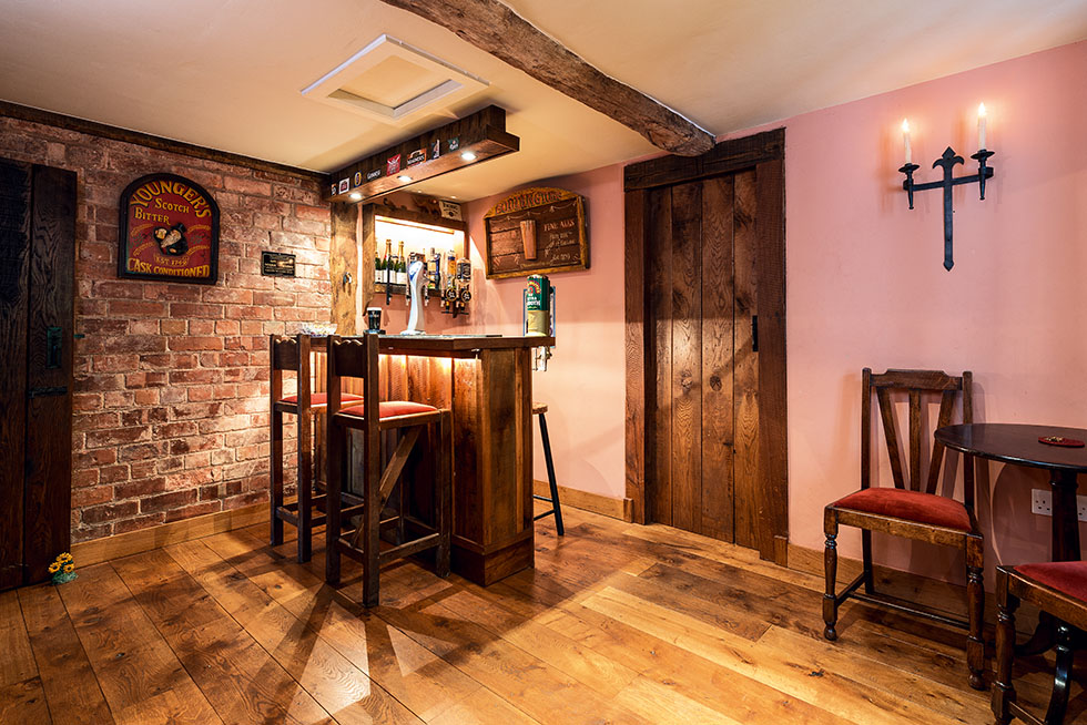 Located off the main dining room, this home bar offers a cosy country pub feel with exposed brickwork, and traditional, handcrafted wooden details. View Project →