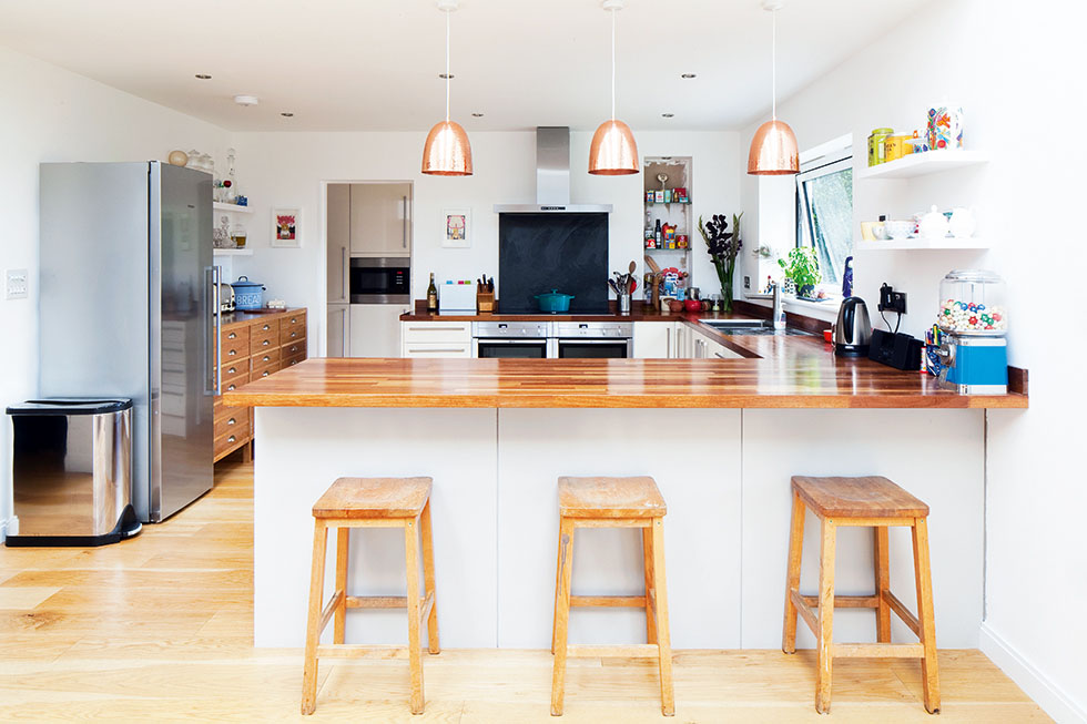 The U-shaped kitchen layout creates a divide between kitchen and dining areas, and the addition of a breakfast bar provides an informal place for drinking and chatting. View Project →