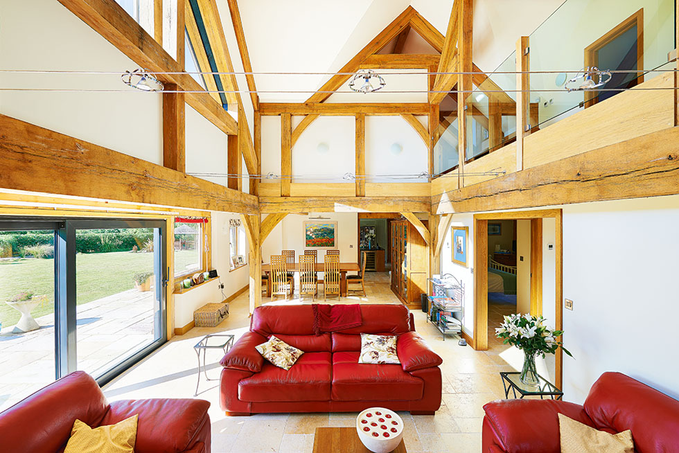 A large, double-height living space is flooded with light thanks to the full-height glazed sections, while separate ‘zones’ are created through furniture placement. View Project →