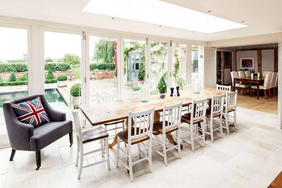 Positioned at the centre of this property, a long dining table in the living kitchen area is the perfect setting for a dinner party, with bi fold doors that open on to the patio. View Project →