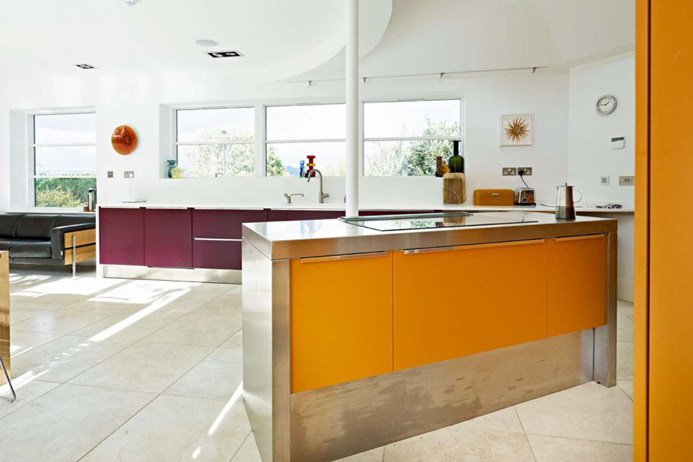 The striking combination of orange and aubergine brings vivid colour to the open plan Effeti kitchen, where a curved ceiling effect adds interest. View Project →