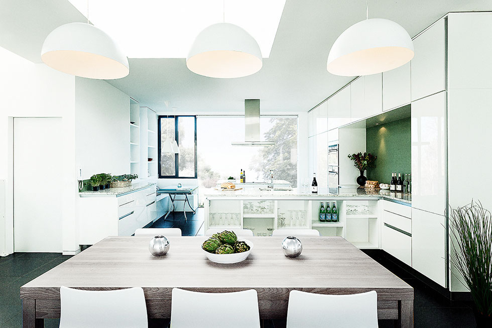 White fittings and furniture enhance the sense of light and space in this kitchen. View Project →