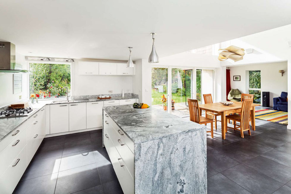 German kitchen cabinets have been teamed with granite worktops, which were honed for a matt finish. The double height dining area is ideal for entertaining. View Project →