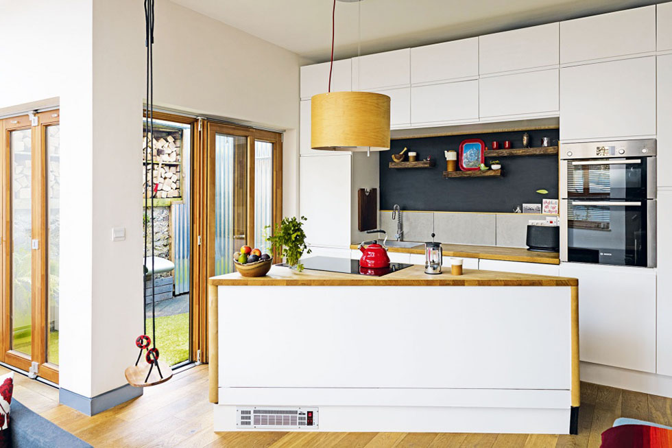 A small but cleverly designed kitchen has units from IKEA, and a triangular island built by the owner with leftover timber from the self build project. View Project →