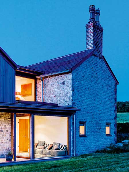Old cottage extension glazed corridor lit at night