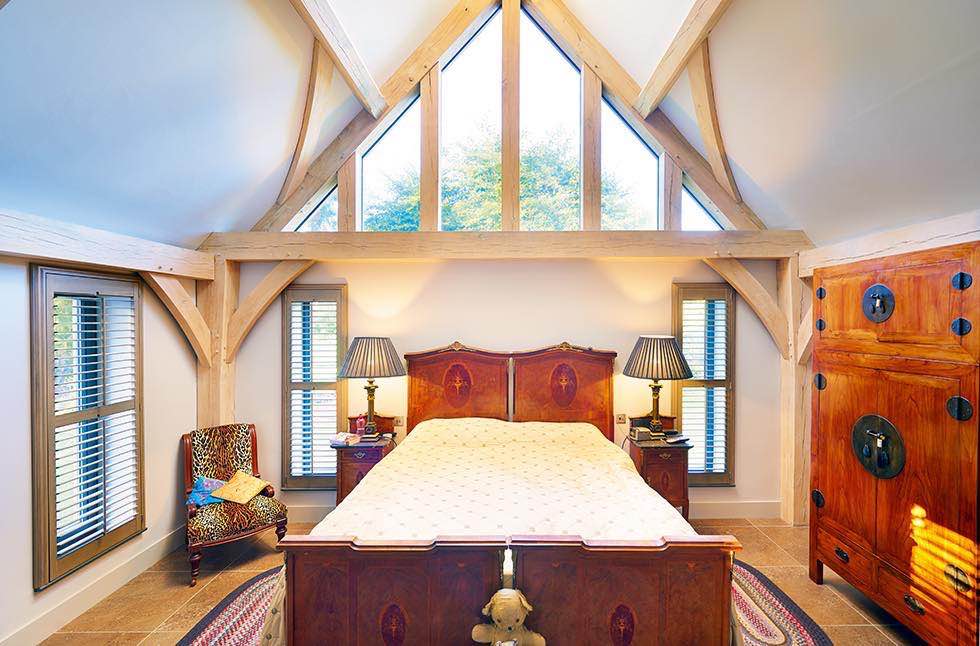 Oakwrights timber frame home bedroom with glazed pitch