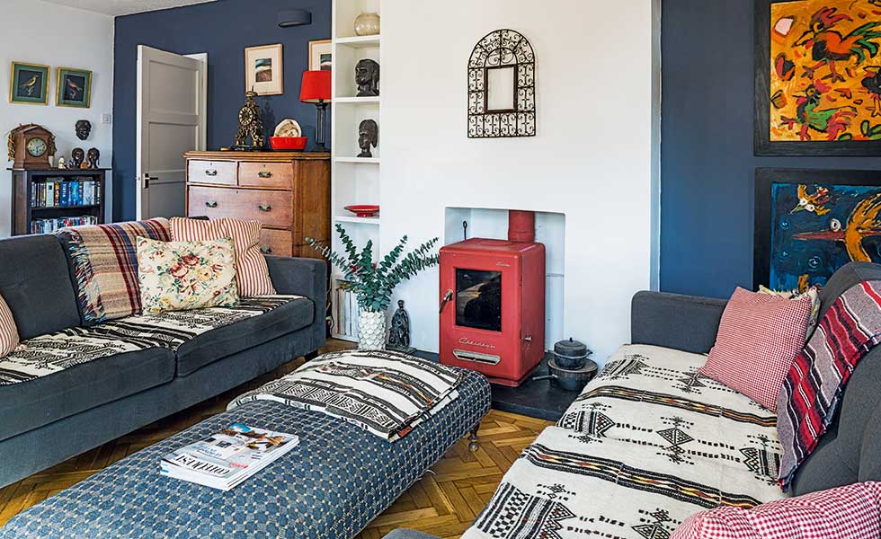 eclectic blue living room with red woodburning stove from Chesneys