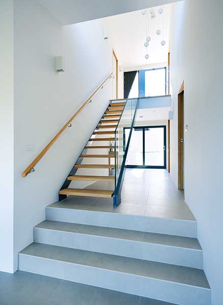 stairwell with white walls and wooden stairs in split level bungalow