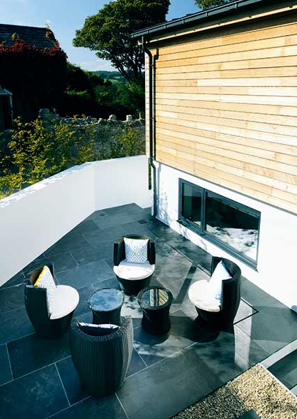 sunken terrace with seating in garden on sloping site
