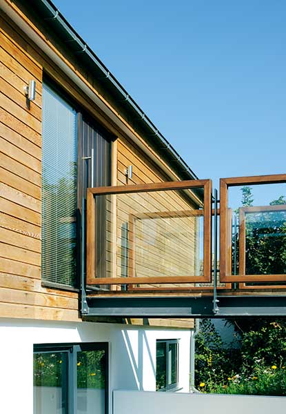 glass and wood walkway entrance to sloping site home