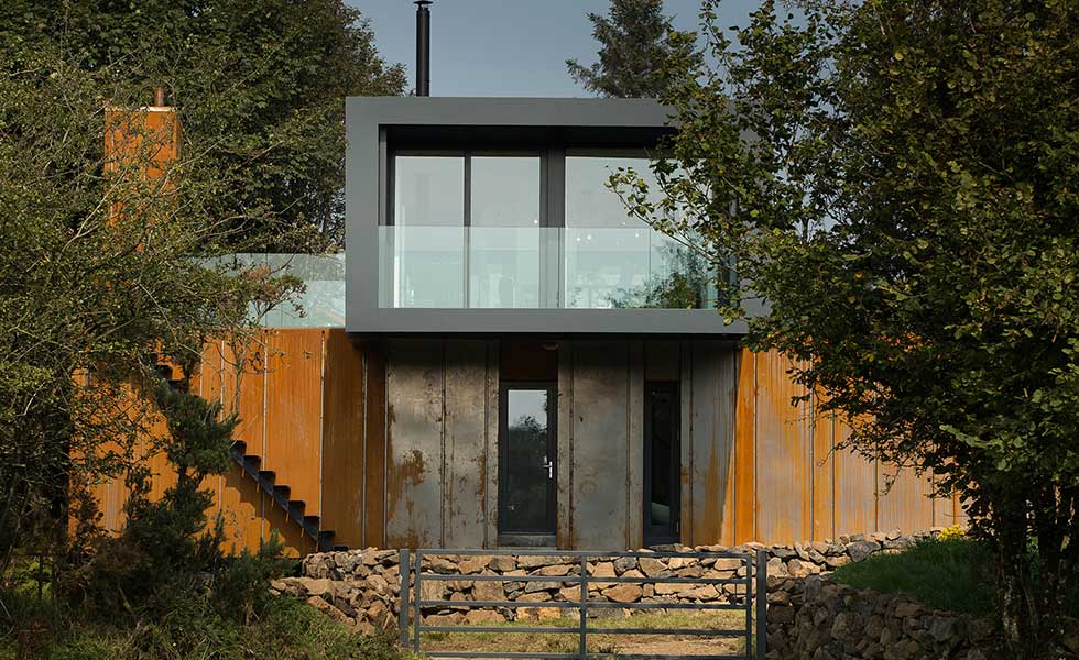 front shot of shipping container house with glass balcony