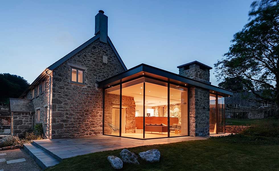 evening shot of glass extension attached to seventeenth century farmhouse