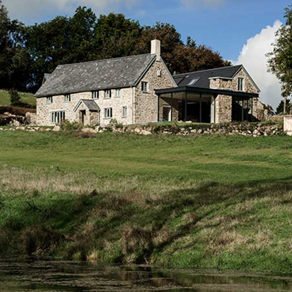 countryside shot of seventeenth century farmhouse with modern glass extension