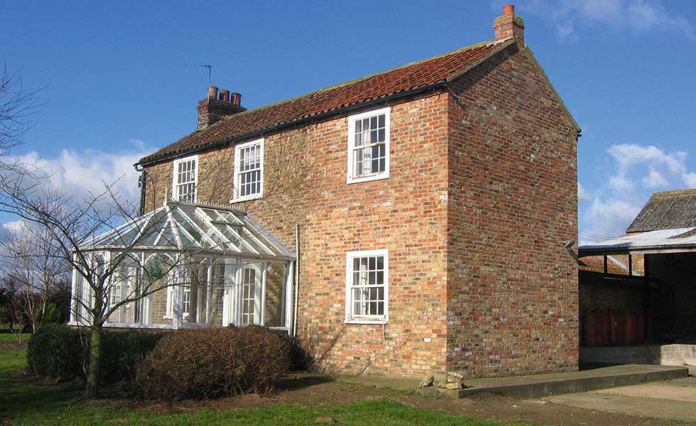 before picture of a brick house with conservatory