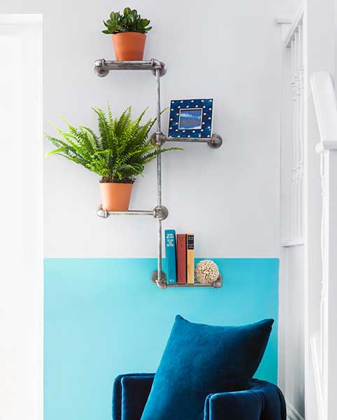 shelving made from pipes in turquoise living room with plants